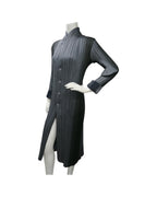 Issey Miyake Pleats Please reversible long pleated coat in gray charcoal and black with notched lapel and button-front closure.