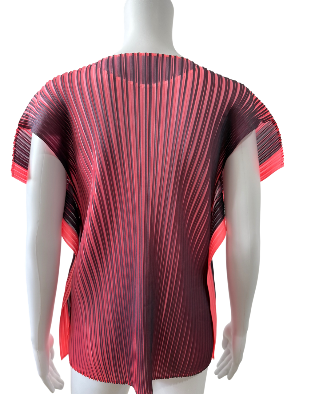 A short-sleeve pleated top displayed on a white mannequin torso. The top features a vertical pleated design with a color gradient transitioning from pink on the sides to a vibrant aubergine 