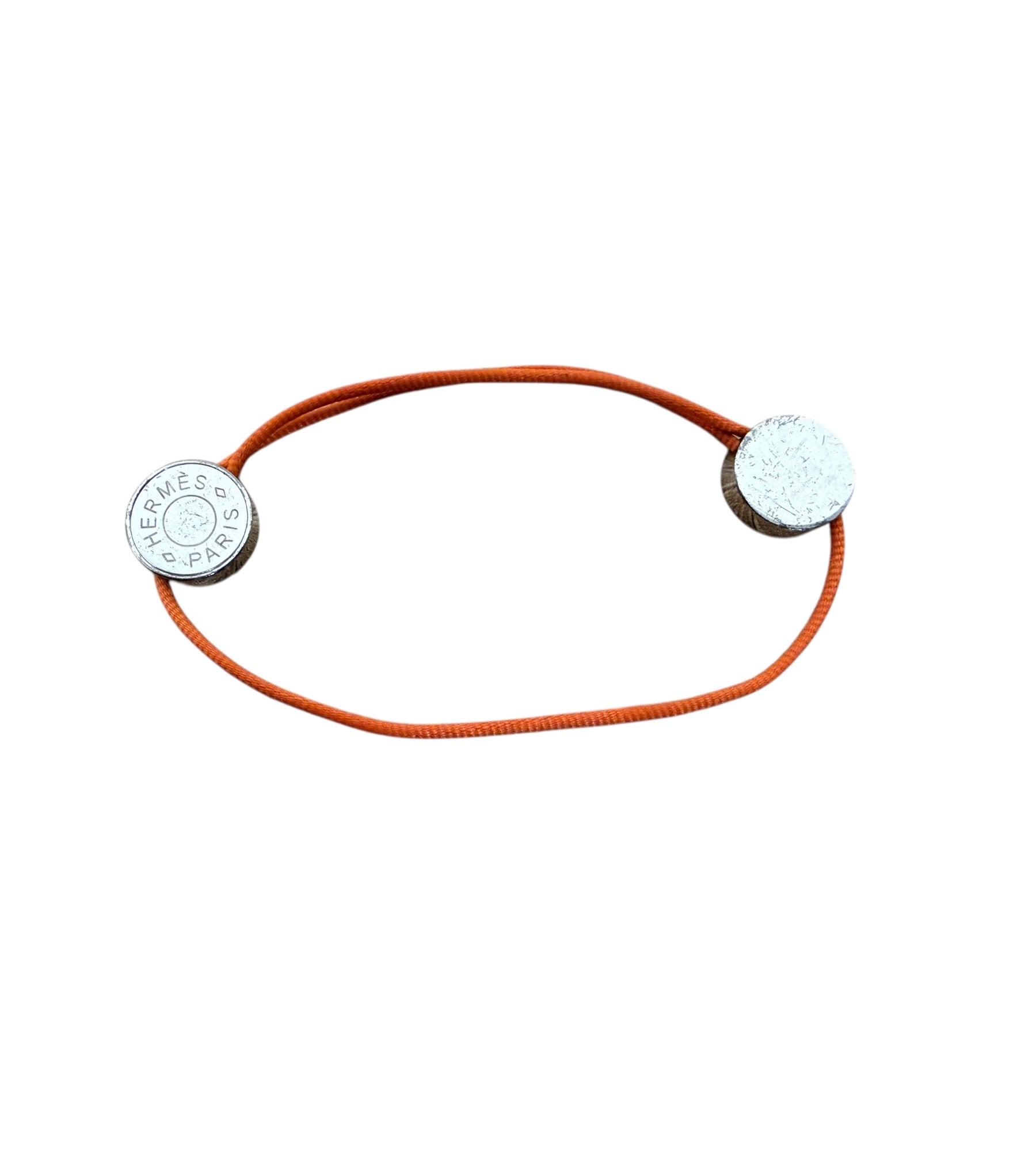 Hermès Clou de Selle adjustable orange cord bracelet with engraved palladium-plated Hermès Paris hardware.